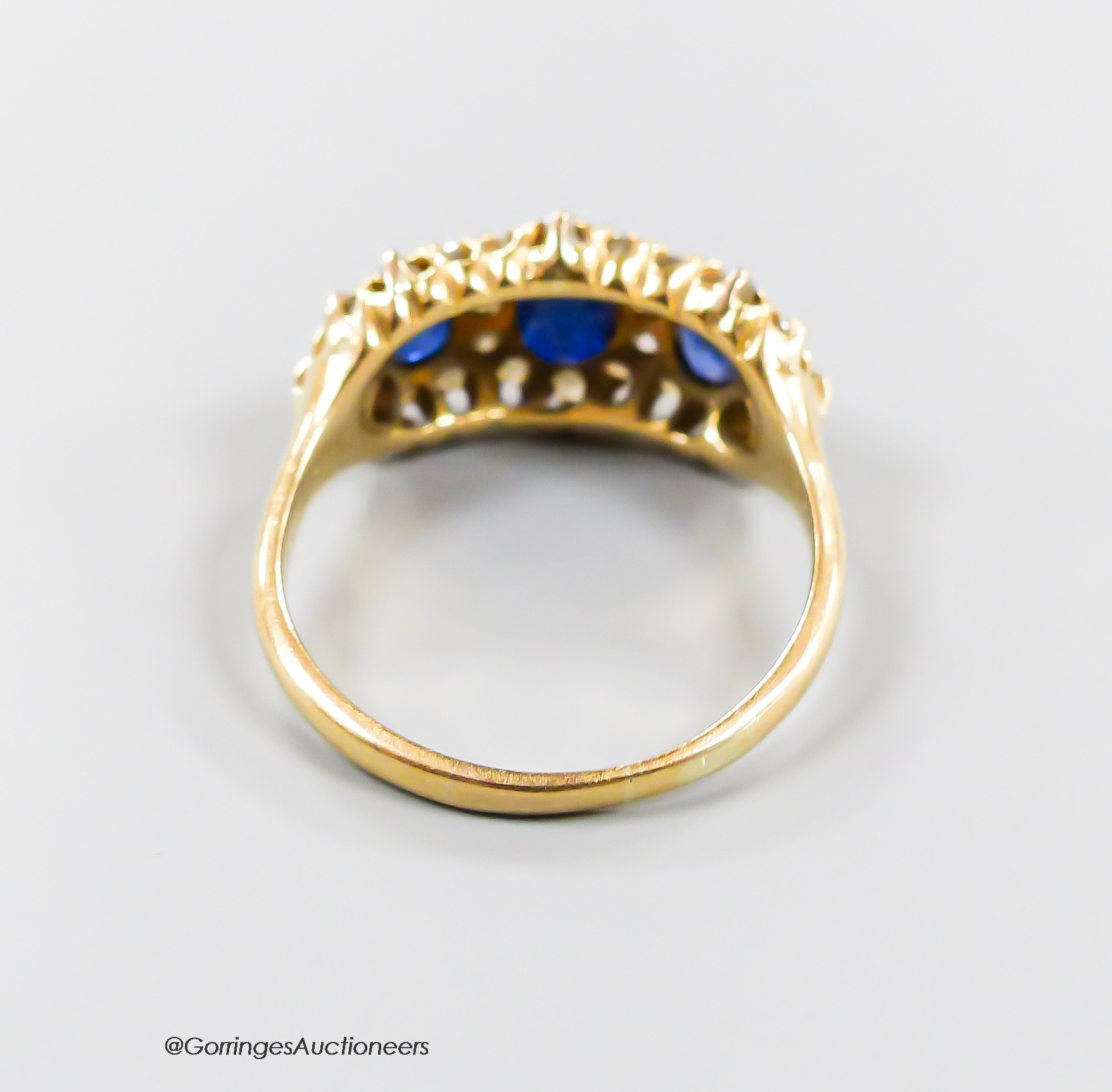 A late Victorian yellow metal, sapphire and diamond set triple cluster ring, with shank inscription, size M, gross weight 3.7 grams.